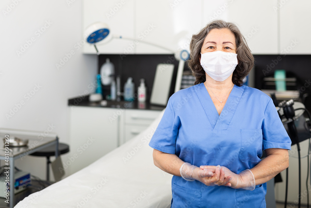 Nurse in protective mask waiting for the patient to the procedure in esthetic clinic. High quality photo