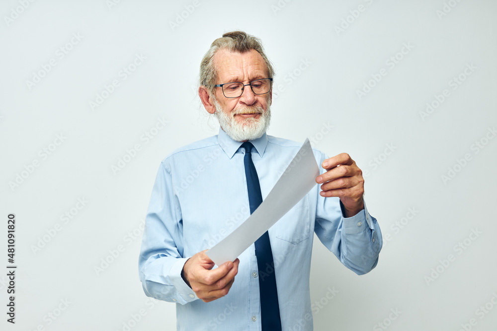Portrait elderly man in a shirt with a tie copy-space sheet of paper isolated background Portrait elderly man in a shirt with a tie copy-space sheet of paper isolated background