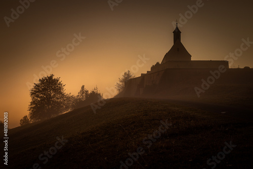 Chapel in the morning fog at dawn. sunrise. sun rays at dawn.