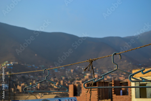 Clothes hooks on a rope, in the background slopes of the populated hills.