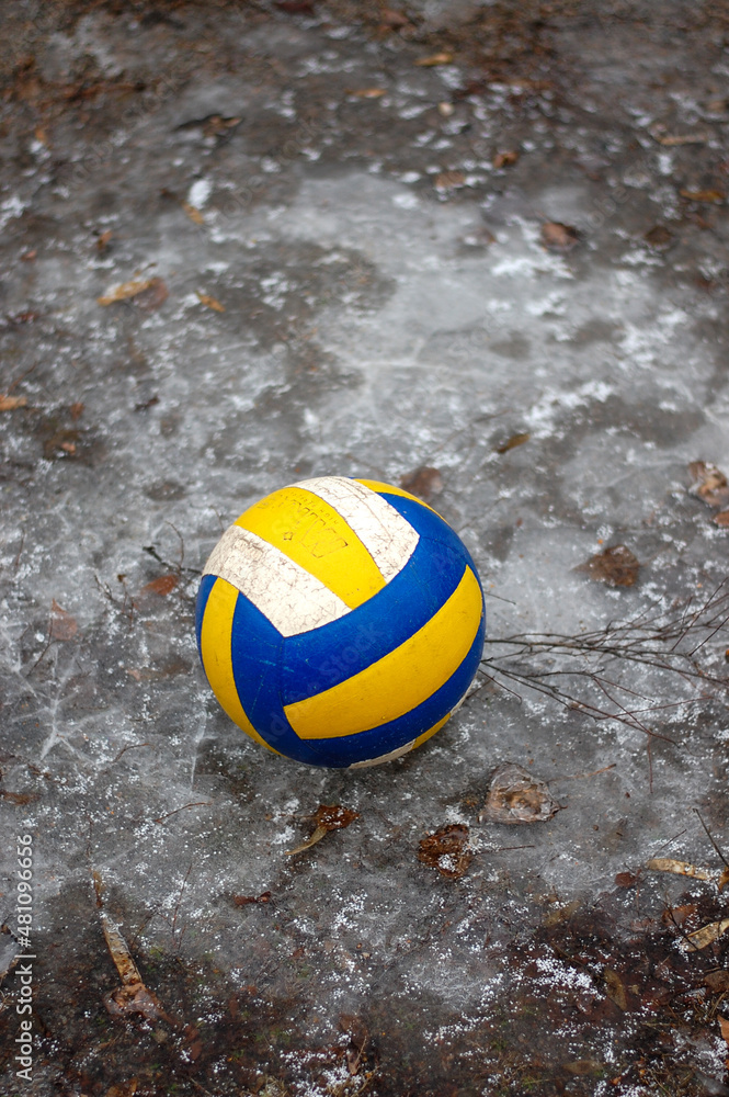 volleyball ball on an open-air sports field covered with frost