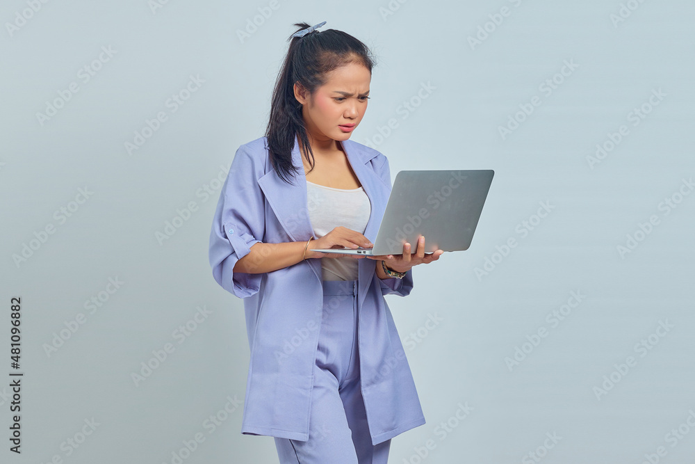 Portrait of surprised young Asian business woman looking at incoming email on laptop isolated on white background Portrait of surprised young Asian business woman looking at incoming email on laptop isolated on white background