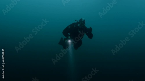 Wallpaper Mural Scuba diver swimming underwater with bubbles and buoyancy exploring the mysterious deep floats towards object with flashlight. Torontodigital.ca