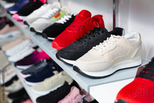 Different colorful sport shoes are on the shelves