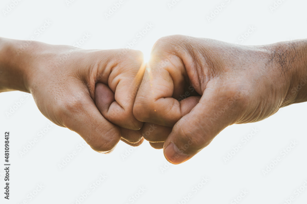 Closeup young man fist bump on the sky background. Friendship & Teamwork Concept. Closeup young man fist bump on the sky background. Friendship & Teamwork Concept.