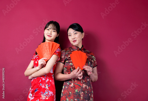 Asian mother and daughter holding red envelopes