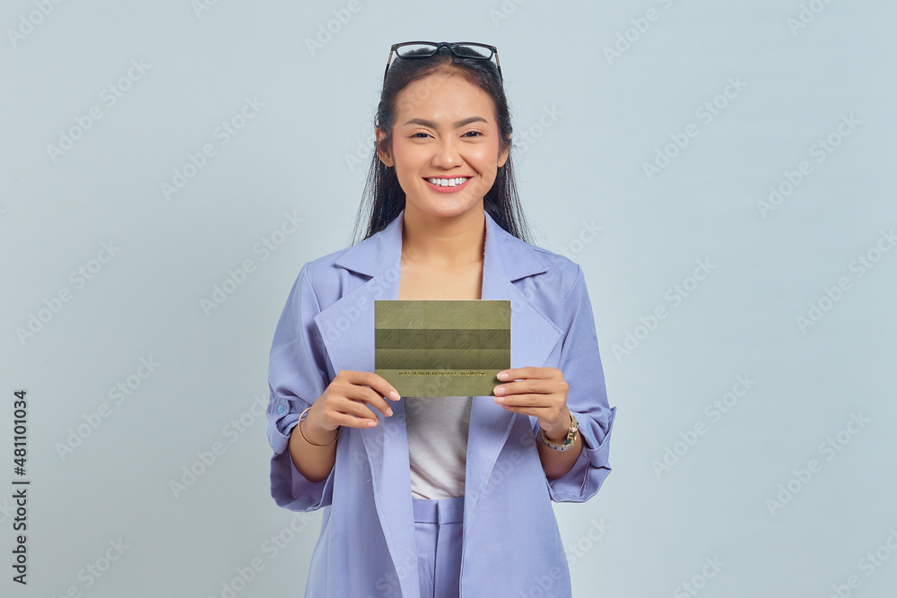 Portrait of smiling young Asian woman holding vehicle book in good mood isolated on white background Portrait of smiling young Asian woman holding vehicle book in good mood isolated on white background
