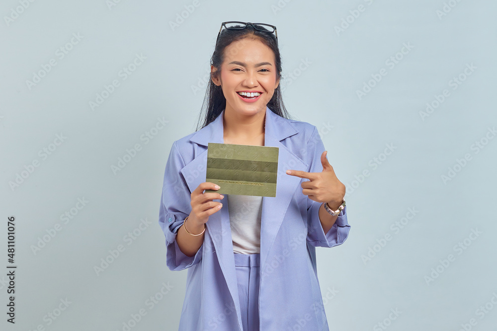 Portrait of cheerful young Asian woman pointing finger at vehicle book isolated on white background Portrait of cheerful young Asian woman pointing finger at vehicle book isolated on white background