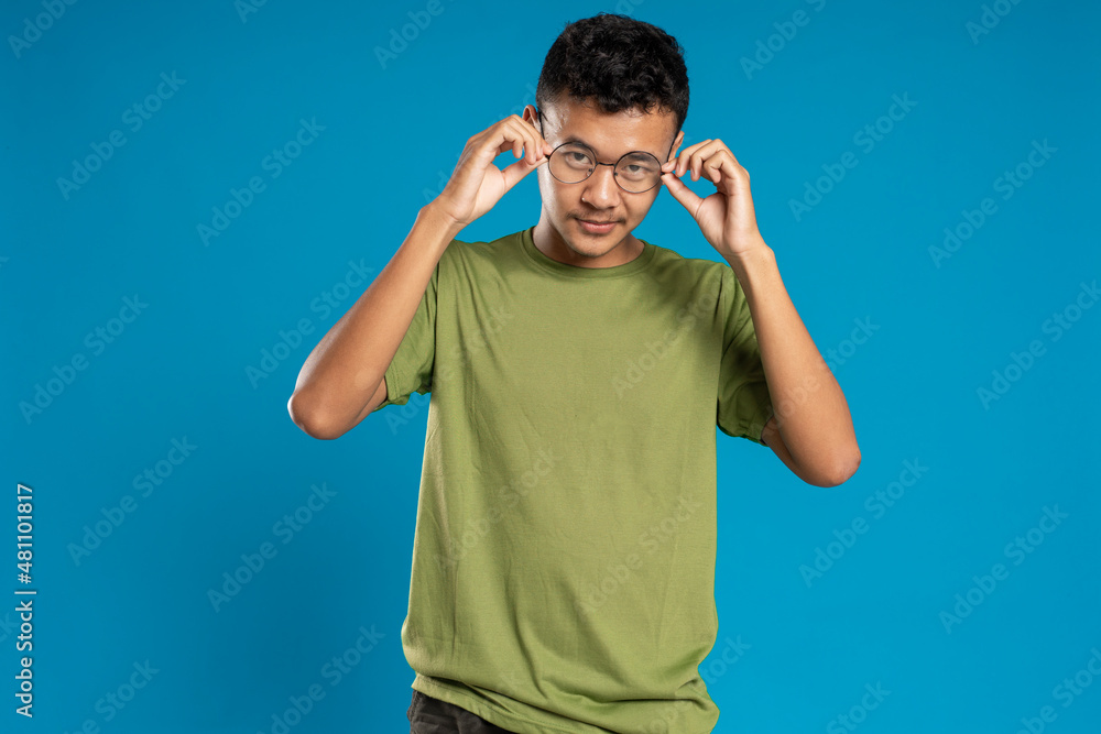 Cheerful smiling young businessman touching his glasses Cheerful smiling young businessman touching his glasses