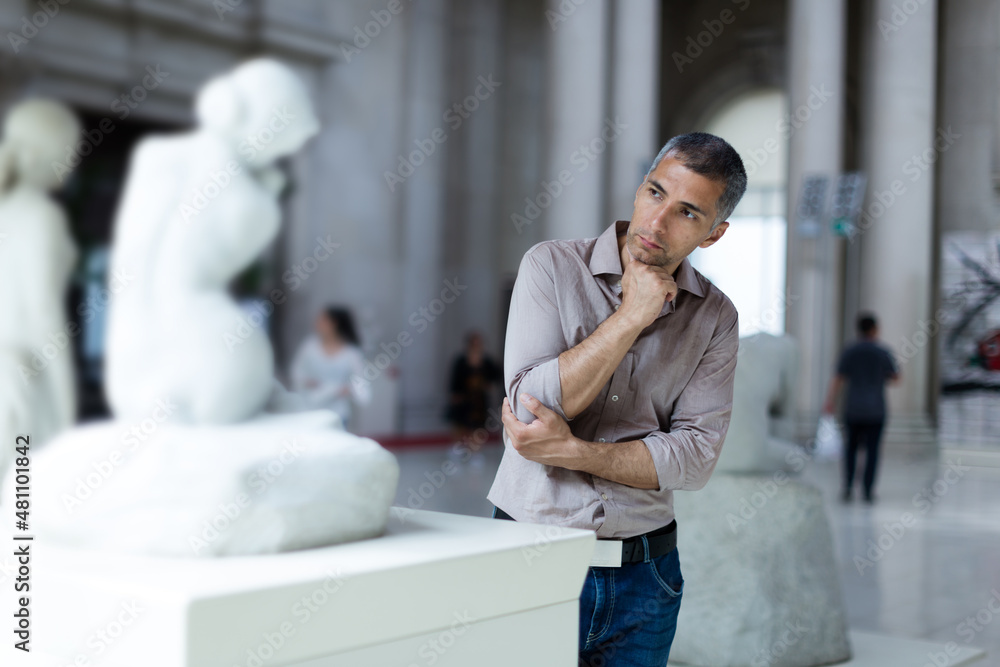 Fototapeta premium Man is looking at the exposition in the museum.
