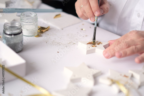 Applying Gold Leaf. woman Artist decorates the gold plaster craft. hobby and creativity concept. photo