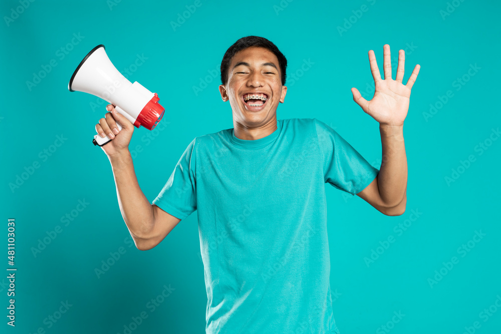 Young man holding a megaphone cheerful and laughing Young man holding a megaphone cheerful and laughing