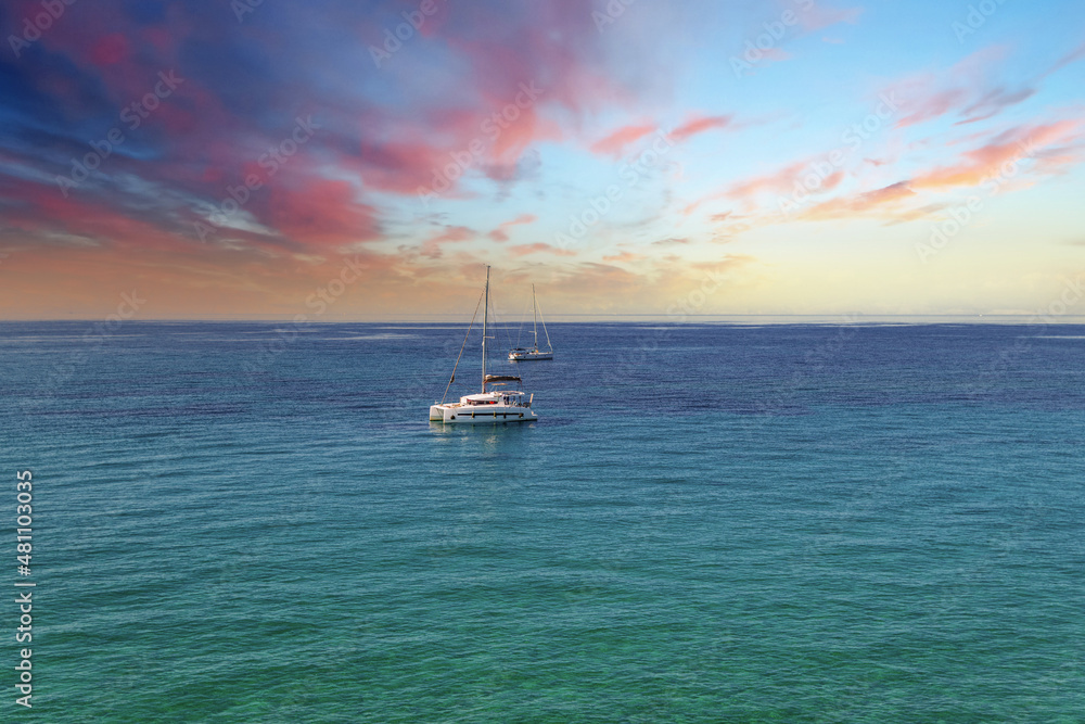 Fototapeta premium Yacht drifting on sea surface under blue cloudless sky
