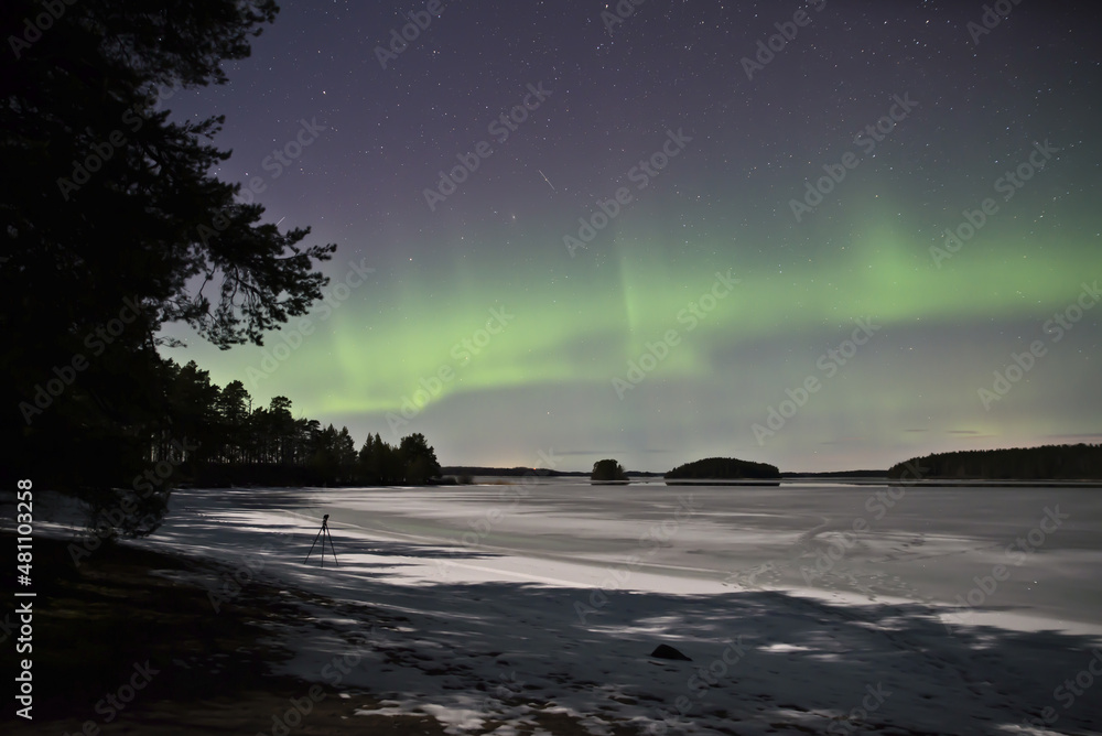 Northern light dancing over frozen lake in north of Sweden,