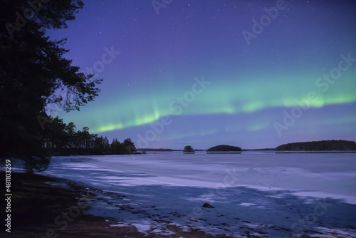 Northern light dancing over frozen lake in north of Sweden,
