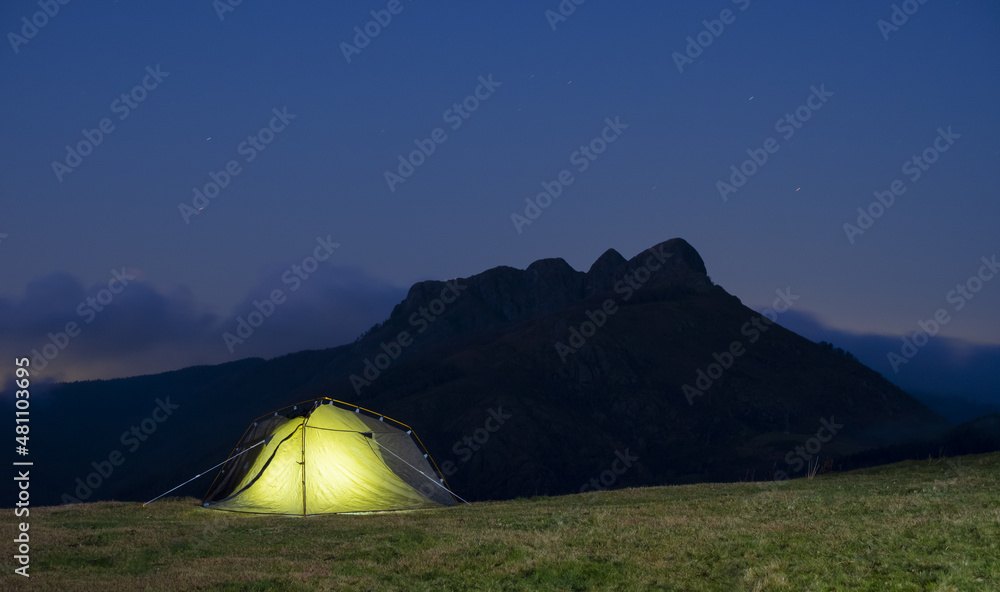 Illuminated tent at night, Aiako harriak natural park in Euskadi.