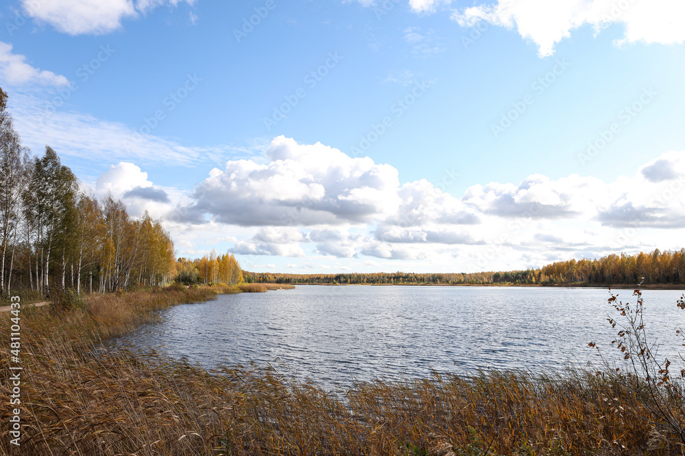 Cloudy Overcast autumn view with small river and cloudy sky.