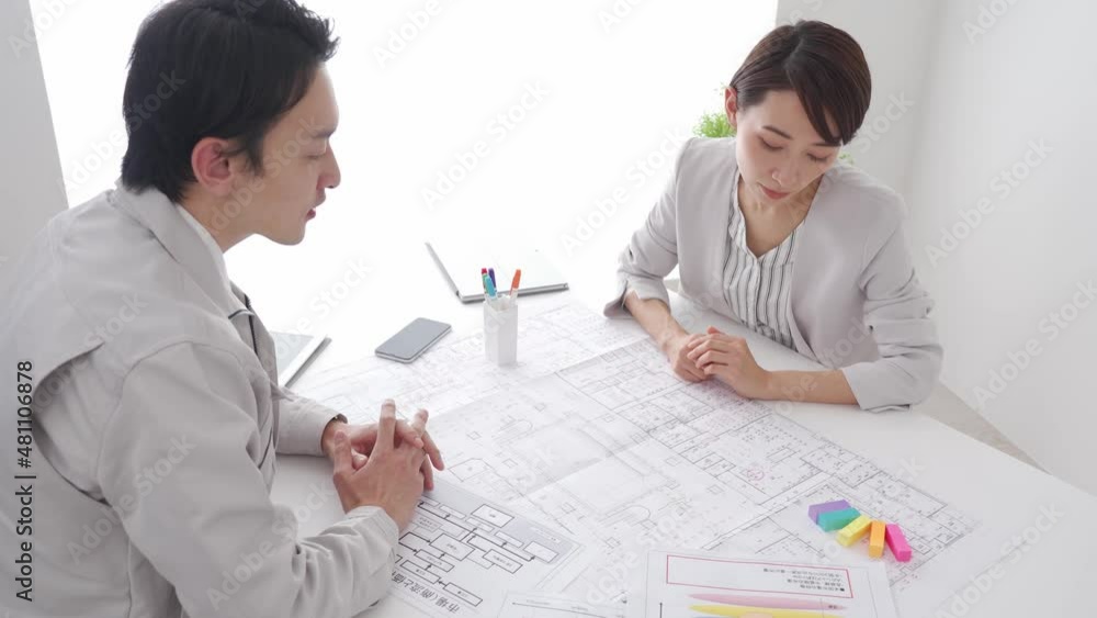 作業着を着た男性とデザイナーの打合せシーン 作業着を着た男性とデザイナーの打合せシーン