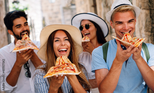 Group of friends eating pizza while traveling on vacation