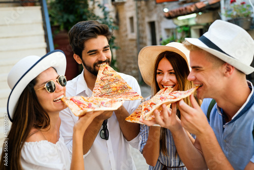 Group of friends having fun outdoor,eating pizza