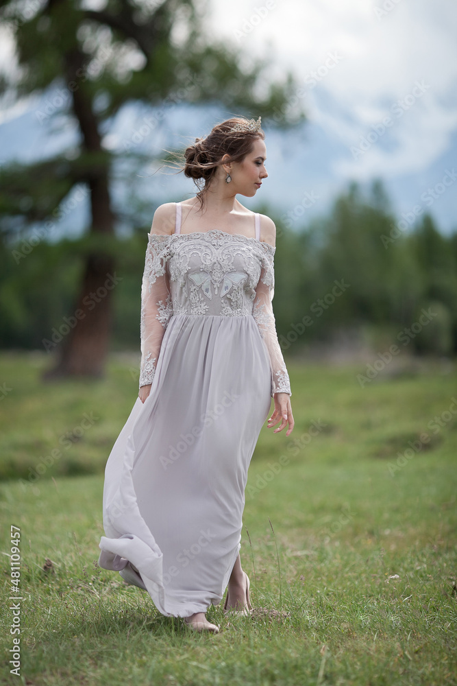 a girl in a royal image, a girl walks against the backdrop of mountains, a girl in a gray dress a girl in a royal image, a girl walks against the backdrop of mountains, a girl in a gray dress