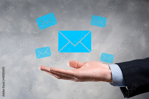 Businessman hand holding e-mail icon, Contact us by newsletter email and protect your personal information from spam mail. Customer service call center contact us concept
