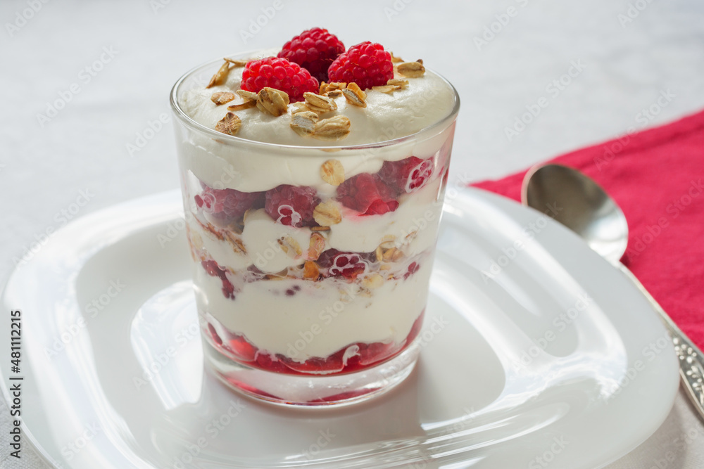 Traditional Scottish Cranachan dessert with toasted oats, fresh raspberries, cream and whisky in a glass close up. Traditional Scottish Cranachan dessert with toasted oats, fresh raspberries, cream and whisky in a glass close up.