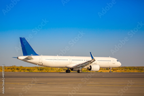 The plane is preparing to fly at the airport. Airplane on the runway at the airport. The turbine of the aircraft is warming up, the landing gear is preparing for flight. The plane flies in the sky.