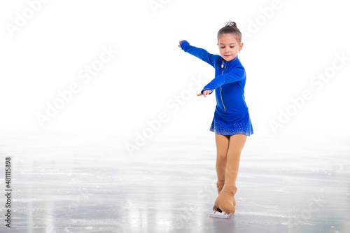 A Little young figure skater posing in blue training dress on ice on white background