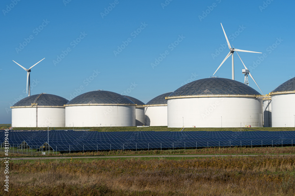 Oil storage tanks, solar panels and wind turbines. Oil storage tanks, solar panels and wind turbines.