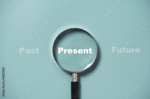 Fotografija Present wording inside of Magnifier glass on blue background for focus current situation , positive thinking mindset concept