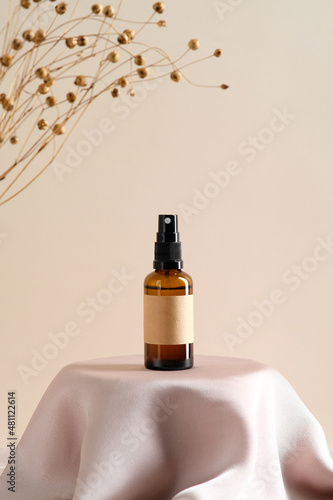 Cuadro en lienzo Brown amber glass spray bottle with label mockup and dry flowers on dais podium on beige background