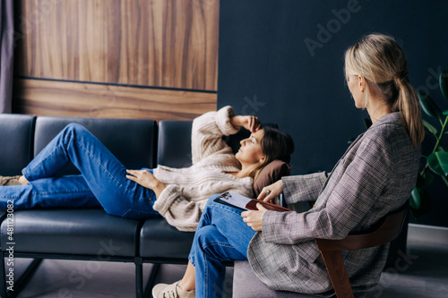 Female therapist listening and consoling a woman talking about problems and traumas in the workshop.