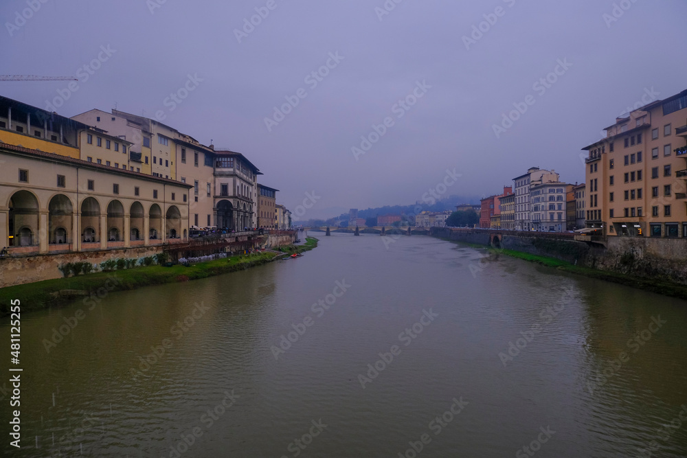 Florence, Italy: View from the Florence Ponte Vecchio on a rainy day on River Arno, canal, and colorful buildings on the banksides