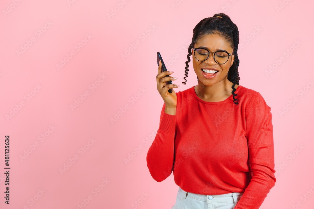 African american woman over isolated pink background sending a message with the mobile African american woman over isolated pink background sending a message with the mobile