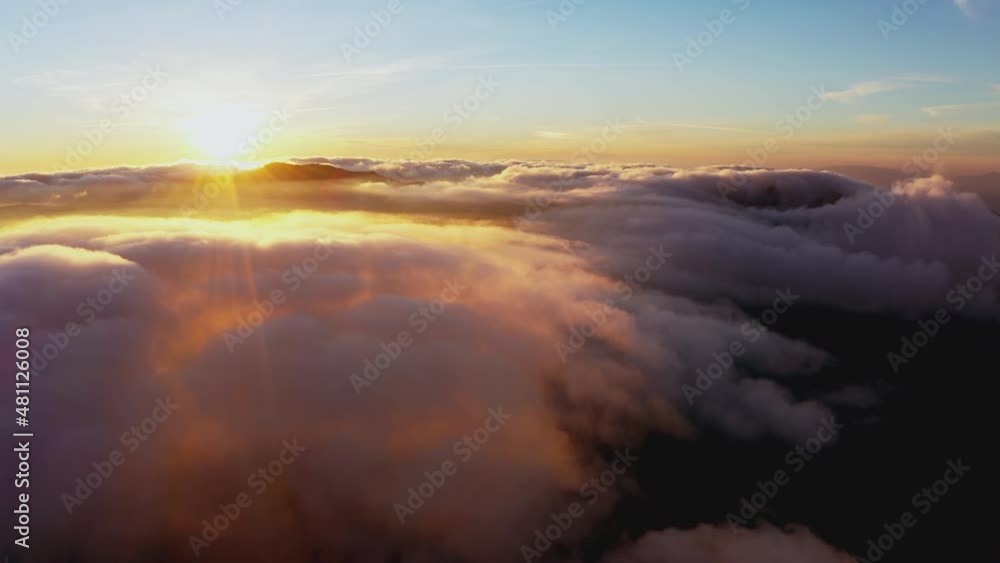 Sun shining brightly above white fluffy clouds at sunrise Sun shining brightly above white fluffy clouds at sunrise