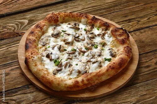 Appetizing pizza with mushrooms on a wooden tray
