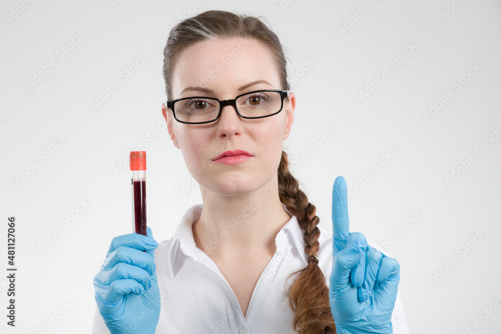 Female doctor or scientist holding a blood probe and is rising a finger for attention Female doctor or scientist holding a blood probe and is rising a finger for attention
