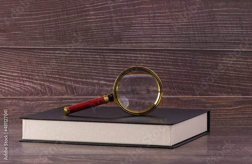 Magnifying glass on book, concept of research