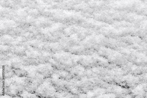 Texture of fluffy snow layer on a vertical dark surface