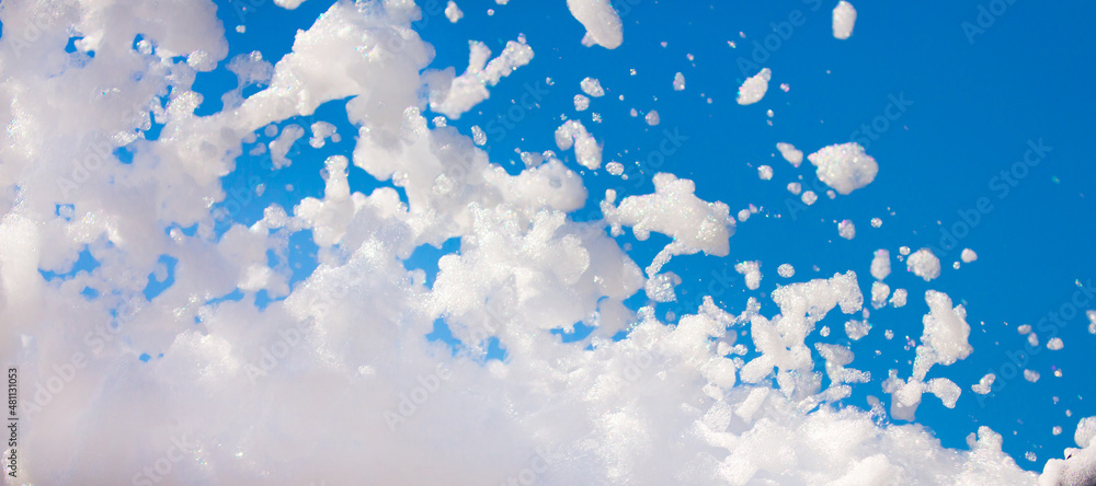 White soap foam on a blue sky background. Fun foam, background or ...