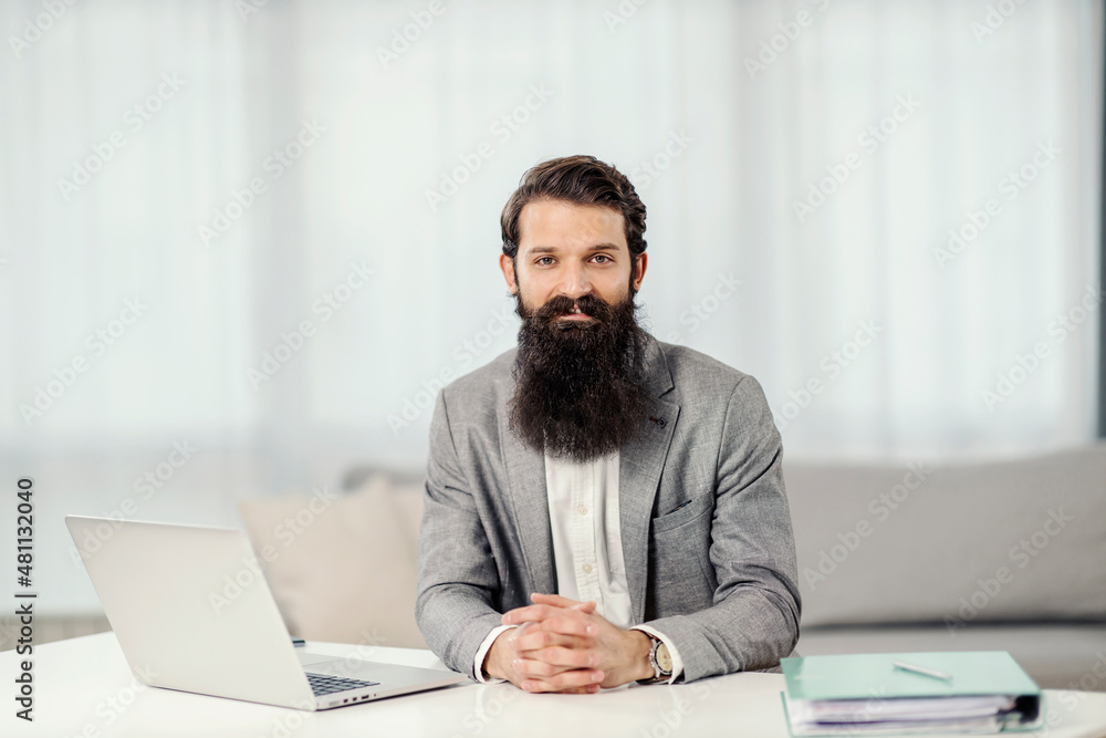Portrait of a successful businessman sitting at his cozy home and smiling. Portrait of a successful businessman sitting at his cozy home and smiling.