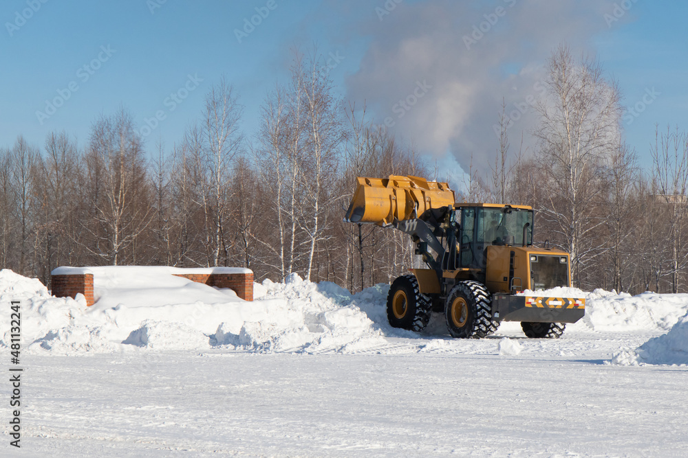 Big yellow tractor cleaning snow parking Big yellow tractor cleaning snow parking
