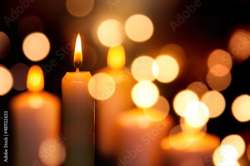 Candlelight Day. Traditional holiday. Group of colored candles lit at night with unfocused lights photo