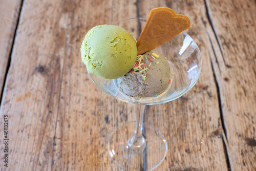 Pistachio and almond ice cream served in a glass with sprinkles and a wafer