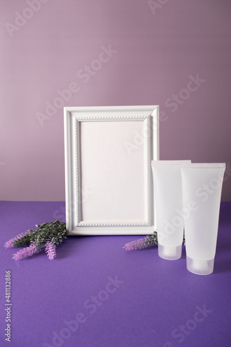 Lavender flowers and leaves creative frame on purple background with plastic cosmetic tube mockup photo