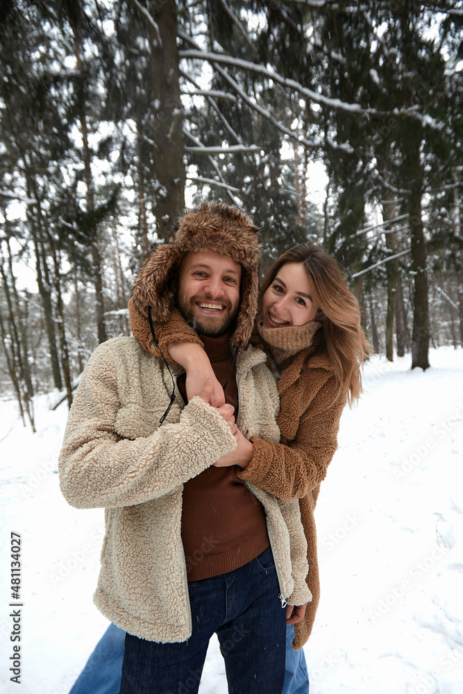 People, season, love and leisure concept - happy couple hugging and laughing outdoors in winter. Couple embracing and having fun in snowy winter park People, season, love and leisure concept - happy couple hugging and laughing outdoors in winter. Couple embracing and having fun in snowy winter park