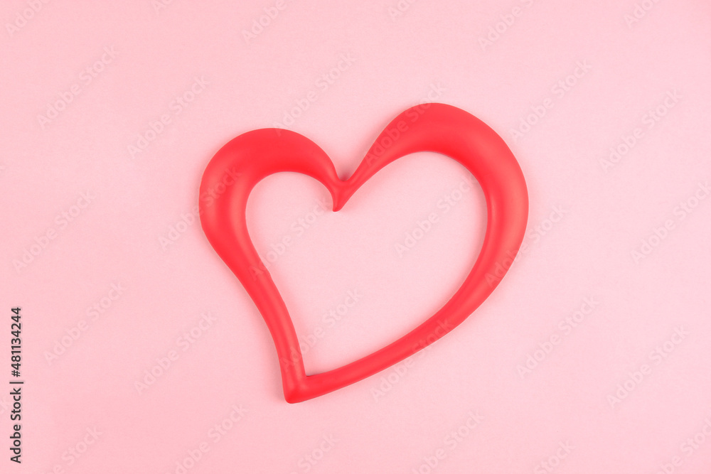 A red empty heart-shaped frame on a pink background. An element of minimalist greeting card design for happy Valentine's Day, Birthday and other holidays.The concept of health, kindness,life.Copyspace