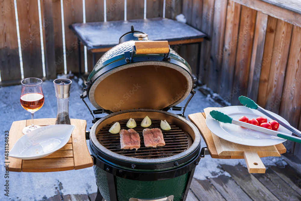 grilling salmon on a ceramic grill with charcoal in the garden at a winter day grilling salmon on a ceramic grill with charcoal in the garden at a winter day