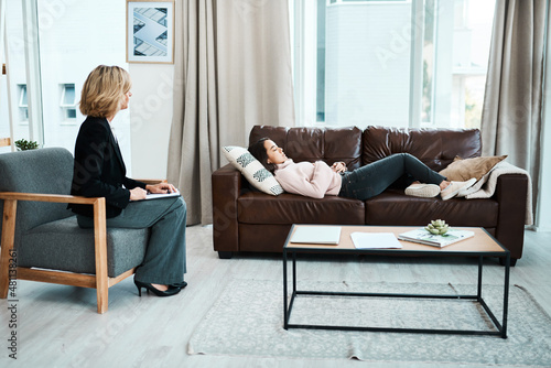 When depression strikes, hypnotherapy may help. Shot of a young woman having a therapeutic session with a psychologist. photo